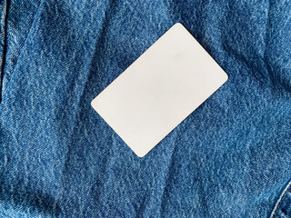 White card on blue jeans close-up