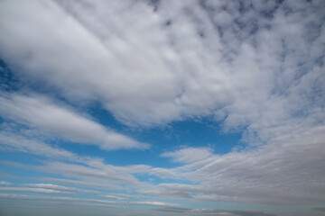 Naklejka na ściany i meble White fluffy clouds on blue sky. Nature background.