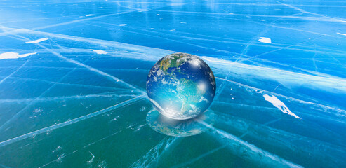 Ice age concept - Glass Globe (planet earth) on transparent ice 