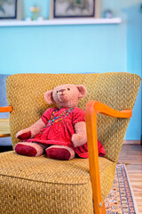 Ein selbstgenähter Teddy sitzt auf einem restaurierten Sessel