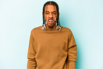 Young African American man isolated on blue background screaming very angry and aggressive.