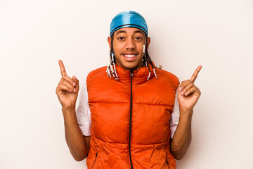 Young African American man isolated on white background indicates with both fore fingers up showing a blank space.