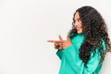 Obraz premium Young hispanic woman isolated on white background points with thumb finger away, laughing and carefree.