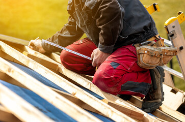 Craftsman or construction worker install a new roof, roofing tools, new metallic roof or metal...