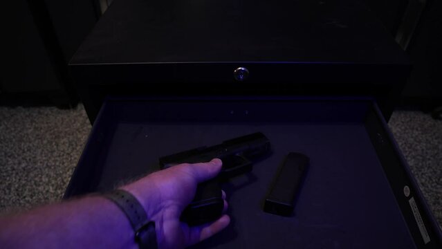 As police lights flash, a man takes a semi-automatic handgun from a drawer