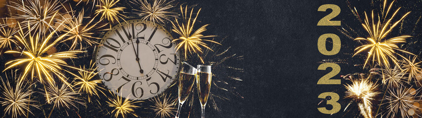 HAPPY NEW YEAR 2023 - Festive silvester New Year's Eve Party background panorama banner long - Golden yellow fireworks, clock and champagne classes toasting in the dark black night