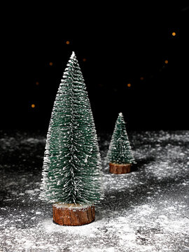 Vertical Shot Of Cute Christmas Tree Ornaments With Fake Snow All Around Them On A Blurry Background