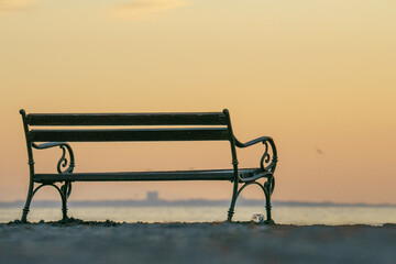 Wooden bench on a lakeshore on a sunset sky background - Powered by Adobe