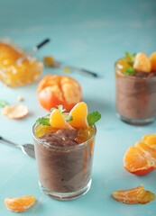 Chocolate mousse dessert with tangerines in glasses	