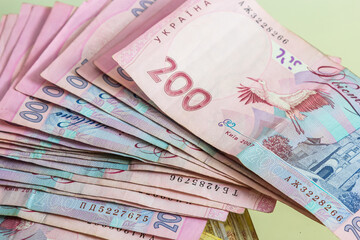 Ukrainian paper money is laid out on a blue background. 200 hryvnia banknotes