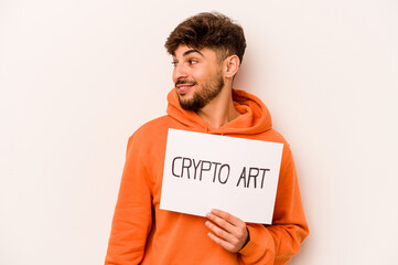 Young hispanic man holding a crypto art placard isolated on white background looks aside smiling, cheerful and pleasant.