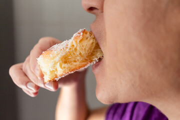 woman biting homemade sugar bread