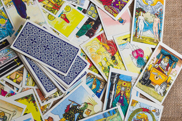 Background with pile of the tarot cards, the major arcana deck. Fortune telling seance or black magic ritual. Scary still life with occult and esoteric symbols. Halloween or divination rite