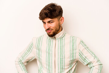 Young hispanic man isolated on white background frowning face in displeasure, keeps arms folded.