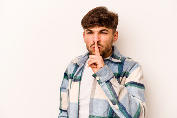 Young hispanic man isolated on white background keeping a secret or asking for silence.