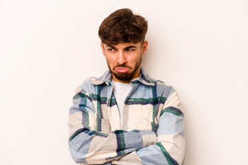 Young hispanic man isolated on white background tired of a repetitive task.