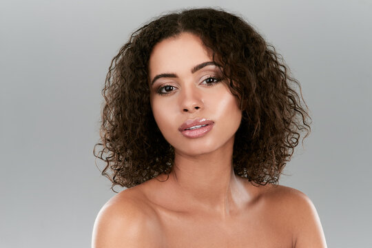 Her skin glows from looking after it. Studio shot of a beautiful young woman posing against a gray background.