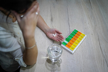 young woman preparing medication at home at the table exhausted, tired