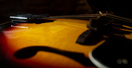 Close up of strigns of mandoline with orange corps. Metal strings close up. String music instrument