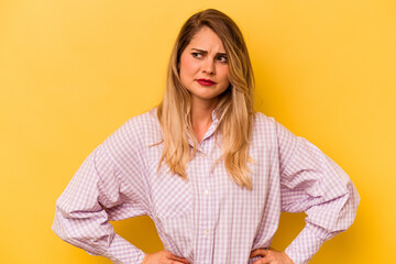 Obraz premium Young caucasian woman isolated on yellow background confused, feels doubtful and unsure.