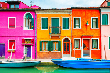 Colorful architecture and canal with boats in Burano island, Venice, Italy. Famous travel...