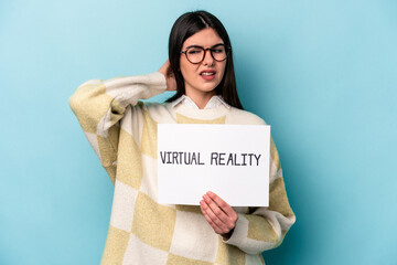 Fototapeta na wymiar Young caucasian woman holding a virtual reality placard isolated on blue background touching back of head, thinking and making a choice.