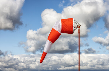 Windsock at an airport with a cloudy sunny sky in background