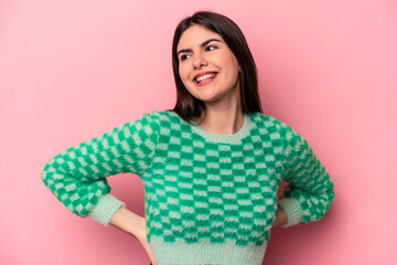 Young caucasian woman isolated on pink background laughs happily and has fun keeping hands on...