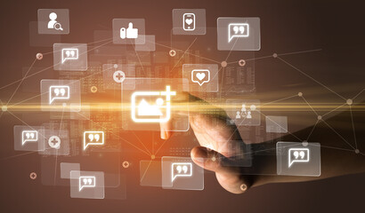 Fototapeta premium Hand pressing social media multimedia application screen with media icons on futuristic concept