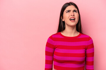 Fototapeta premium Young caucasian woman isolated on pink background shouting very angry, rage concept, frustrated.