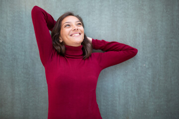 carefree young woman relaxing with hands behind head