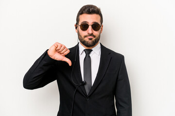 Young caucasian bodyguard man isolated on white background showing a dislike gesture, thumbs down....