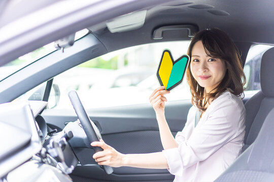 初心者マークを持った若い女性ドライバー