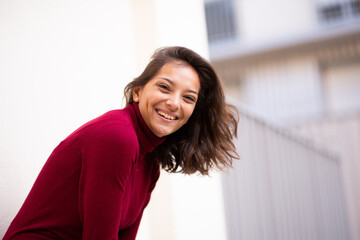 Side of beautiful young mixed race woman laughing outside