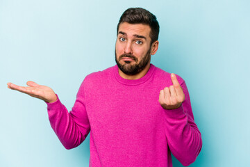Young caucasian man isolated on blue background showing that she has no money.