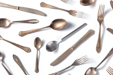 Cutlery pattern. Various forks, knives, and spoons, elegant tableware, overhead flat lay shot on a white background