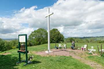 Une femme de confession catholique en m&eacute;ditation devant la croix de Dozul&eacute; 