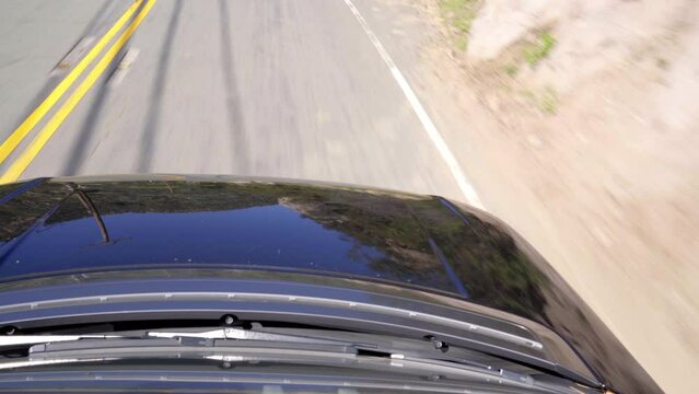 Driving black Range Rover uphill at high speed. POV top down view