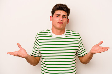 Fototapeta premium Young caucasian man isolated on white background doubting and shrugging shoulders in questioning gesture.