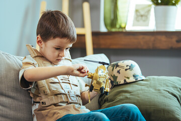 Little boy playing soldiers in living room. Little child is playing with toy. Knights and battles -...