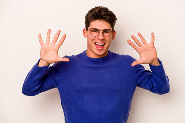 Naklejka premium Young caucasian man isolated on white background showing number ten with hands.