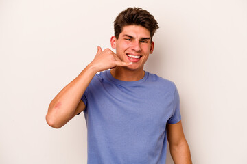 Obraz premium Young caucasian man isolated on white background showing a mobile phone call gesture with fingers.