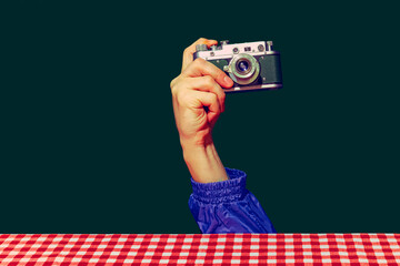 Concept of pop art photography. Using retro gadgets. Human hand holding photo camera isolated on...