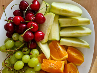 Apple, Orange, grape, and Cherry fruits on plate. Nutrition fruits for health. Fruits salad