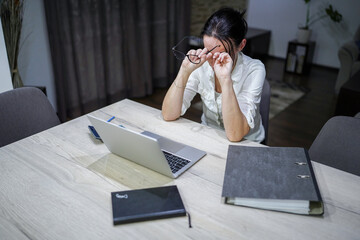 young woman working at home on computer, tired, exhausted