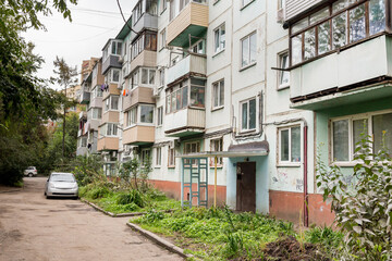 Fototapeta na wymiar Courtyard of Khrushchyovka, common type of old low-cost apartment building in Russia and post-Soviet space. Kind of prefabricated buildings. Built in 1960s. Russia, Vladivostok.