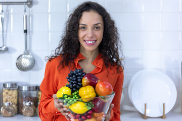 Young woman holding fruits in the kitchen, Healthy eating food concept.