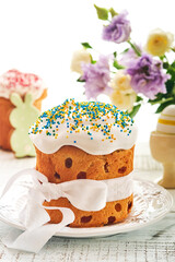Traditional Easter sweet bread or cakes with white icing and sugar decor and quail eggs over white wooden table. Various Spring Easter cakes. Happy Easter day. Christian traditions. Top view.
