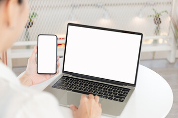 Fototapeta premium computer screen,cell phone blank mockup.hand woman work using laptop texting mobile.white background for advertising,contact business search information on desk in cafe.marketing,design