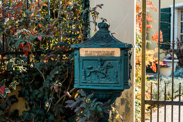 Ancient cast iron mailbox standing on a sidewalk with the word letters carved on it